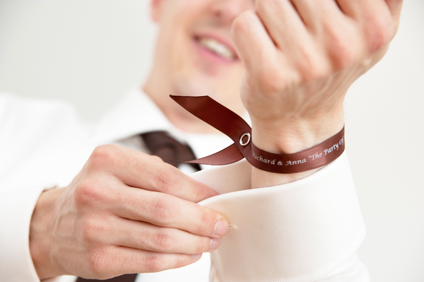 brudgum får armband av brud till bröllop med festivaltema