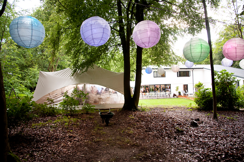 Bröllop i trädgård festivaltema med rislampor och partytält