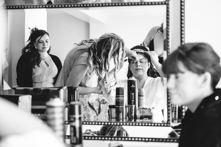 brud sminkas inför bröllop i lagerlokal