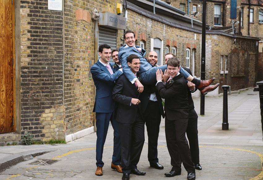 Marskalkar bär brudgum till bröllop i lagerlokal