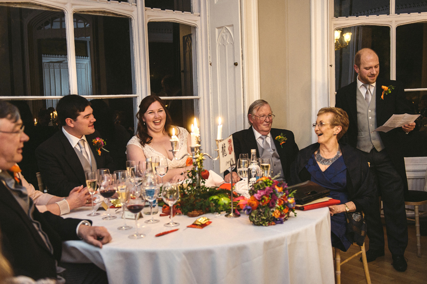 brudpar skrattar åt tal av best man under mottagning